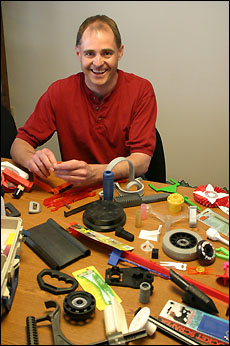 Bruce Stang seated at a table displaying a variety of manufactured products